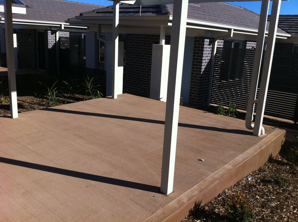 Coloured Concrete Wheelchair Accessible Path Adjacent To Driveway With Aluminium Privacy Fencing